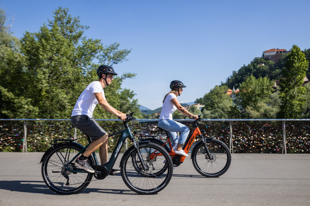 Radfahrende fahren bei sommerlichem Wetter über eine Brücke