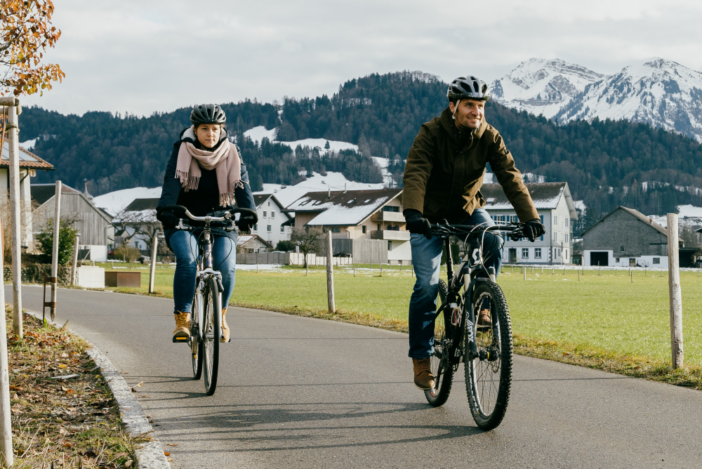 Mann und Frau fahren im Winter mit dem Fahrrad.